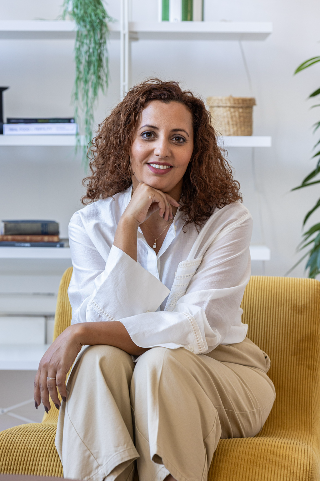 Portrait souriant de la fondatrice de Fertilience, assise sur un canapé jaune