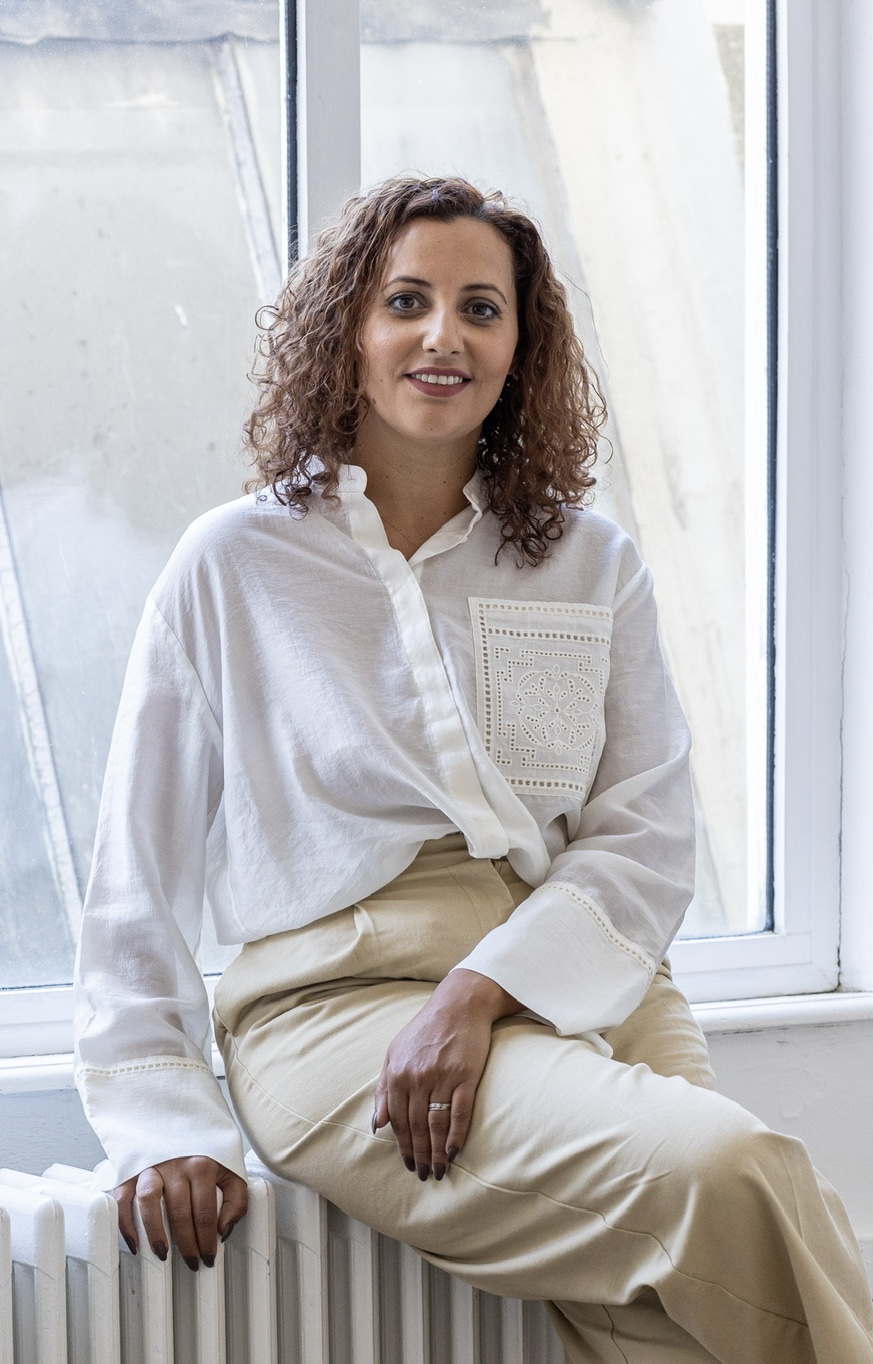 La fondatrice de Fertilience, souriante, assise devant une fenêtre lumineuse